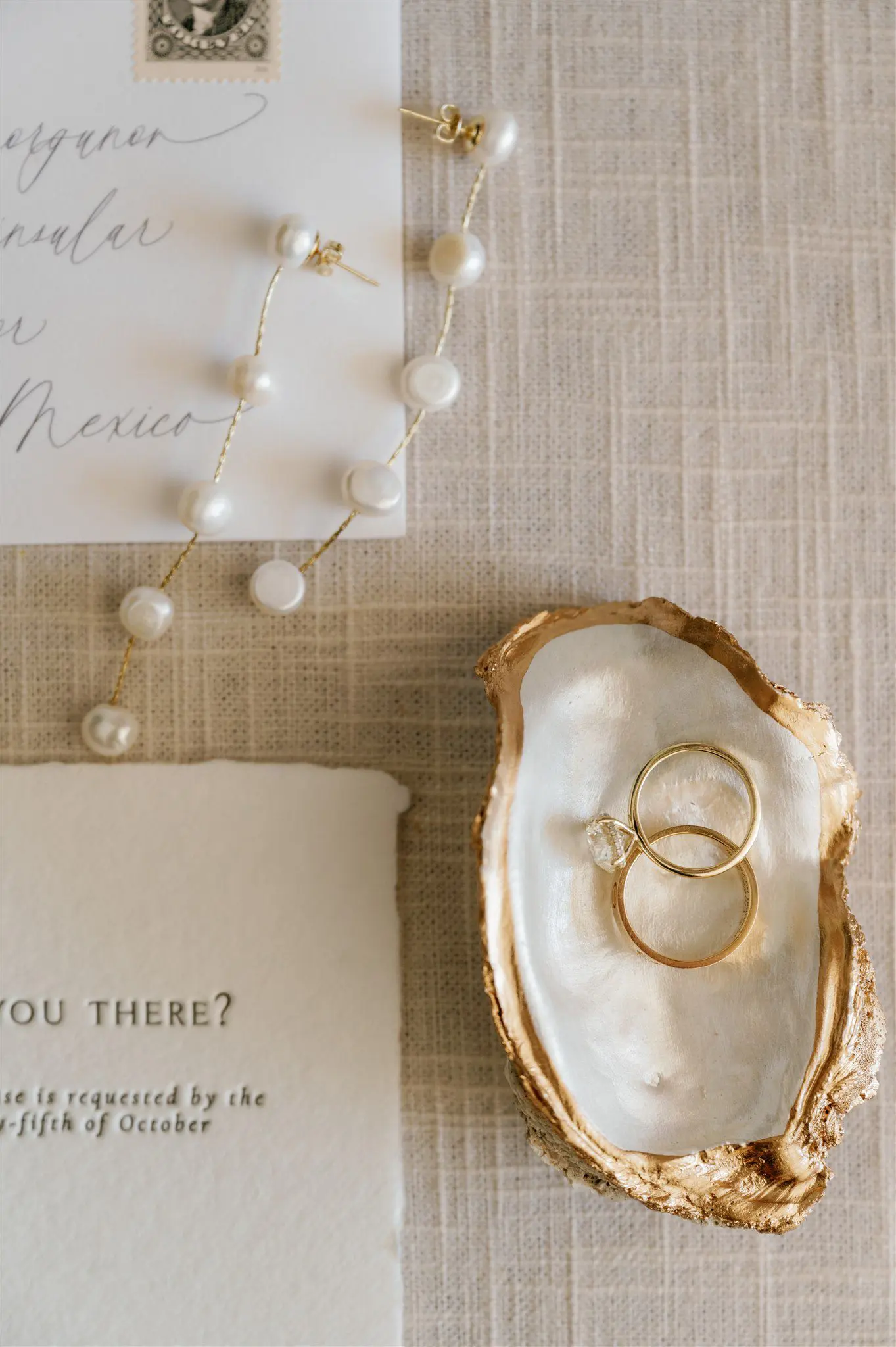 Pearl earrings and beach-inspired wedding flatlay
