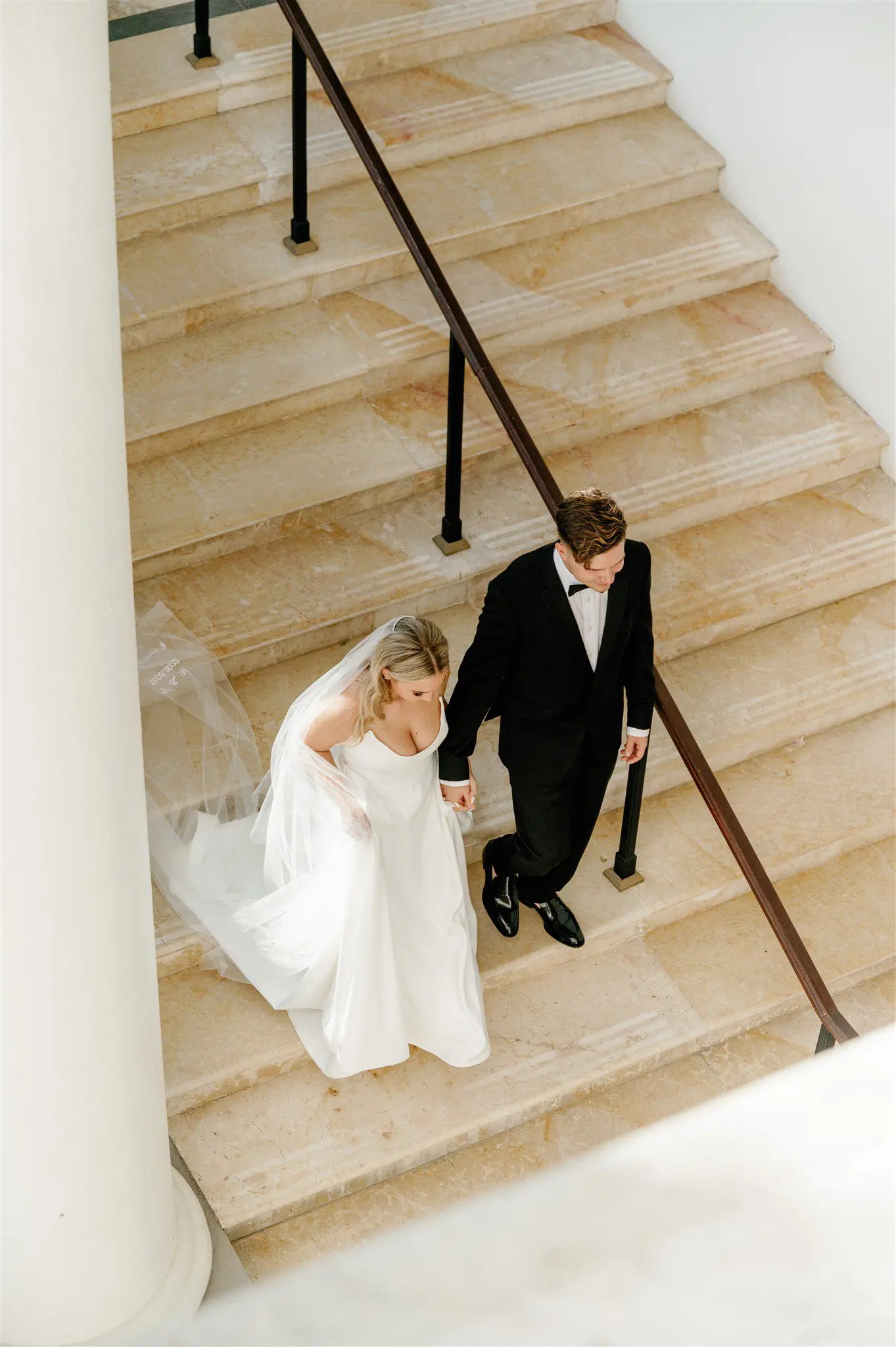 Bride and groom walking down the stairs at the Hilton Cabo wedding venue