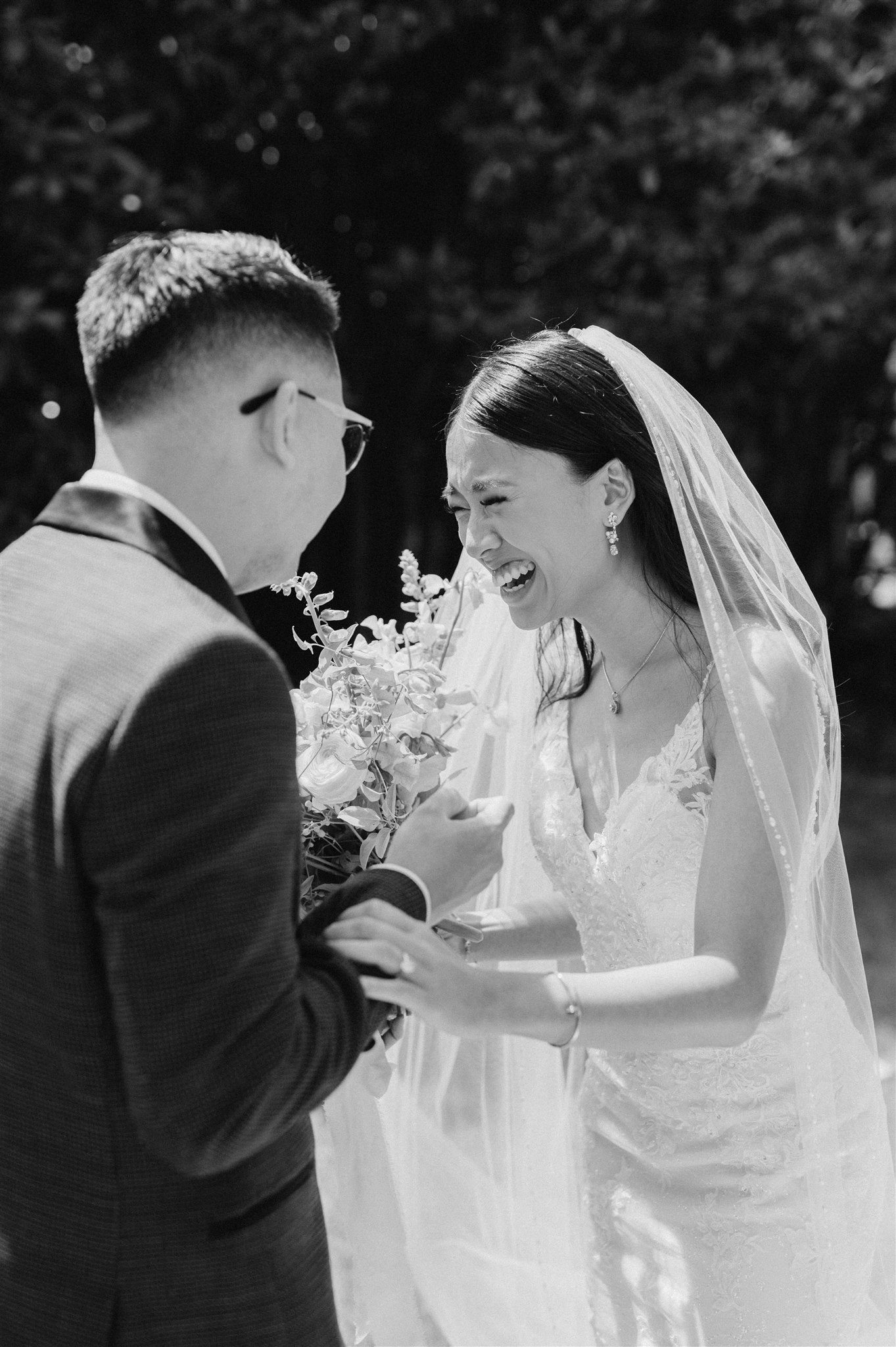 Black and white photo of first look between bride and groom in a garden