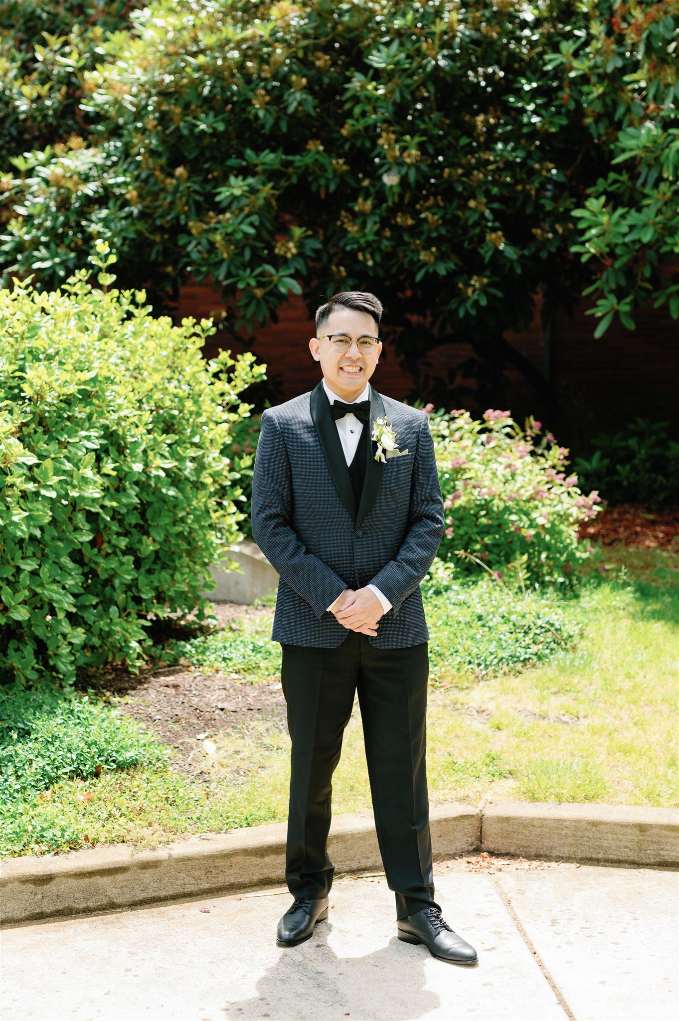 Groom standing in a garden in a suit