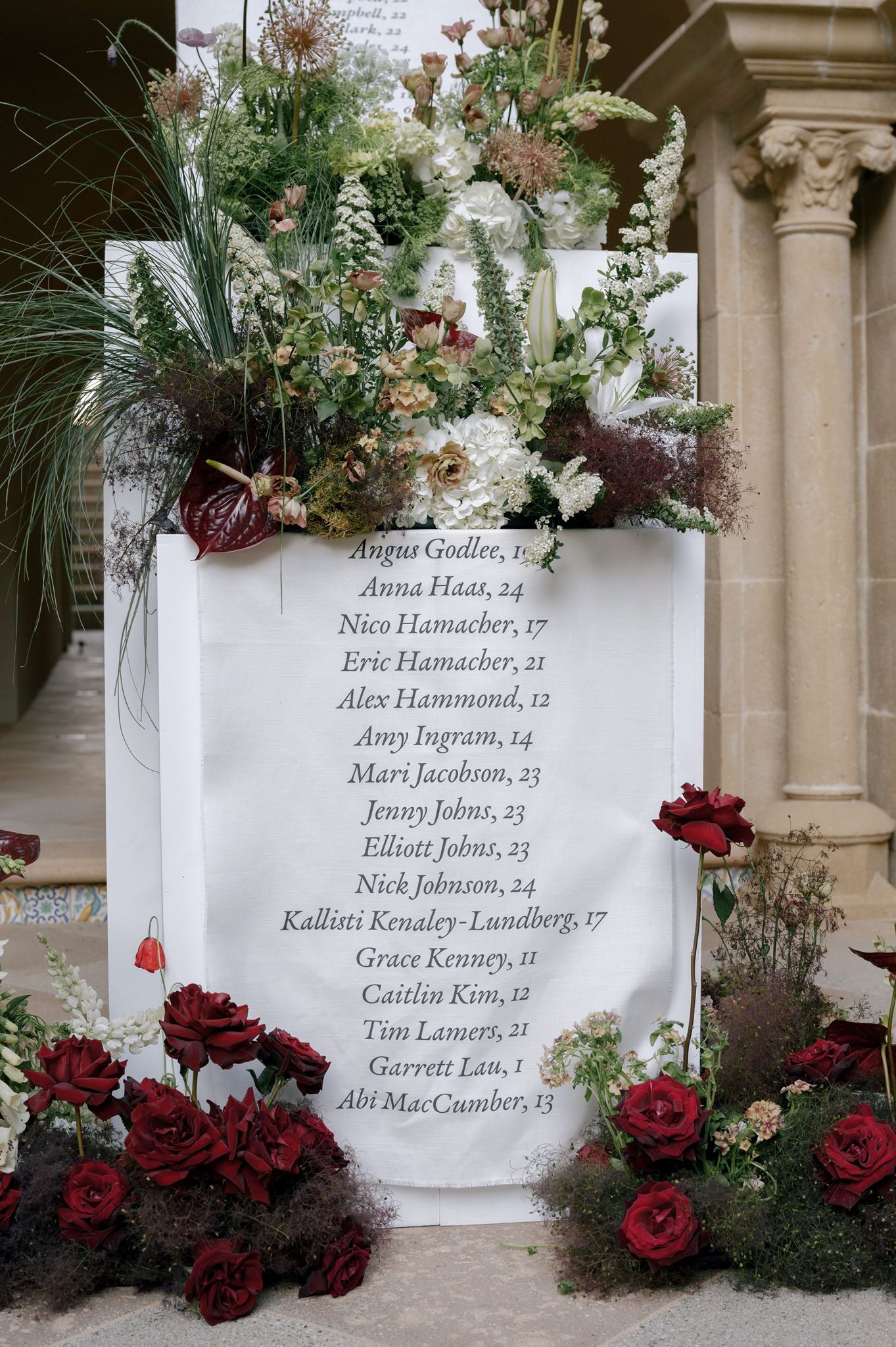 Grand linen seating chart and florals at a private estate wedding venue