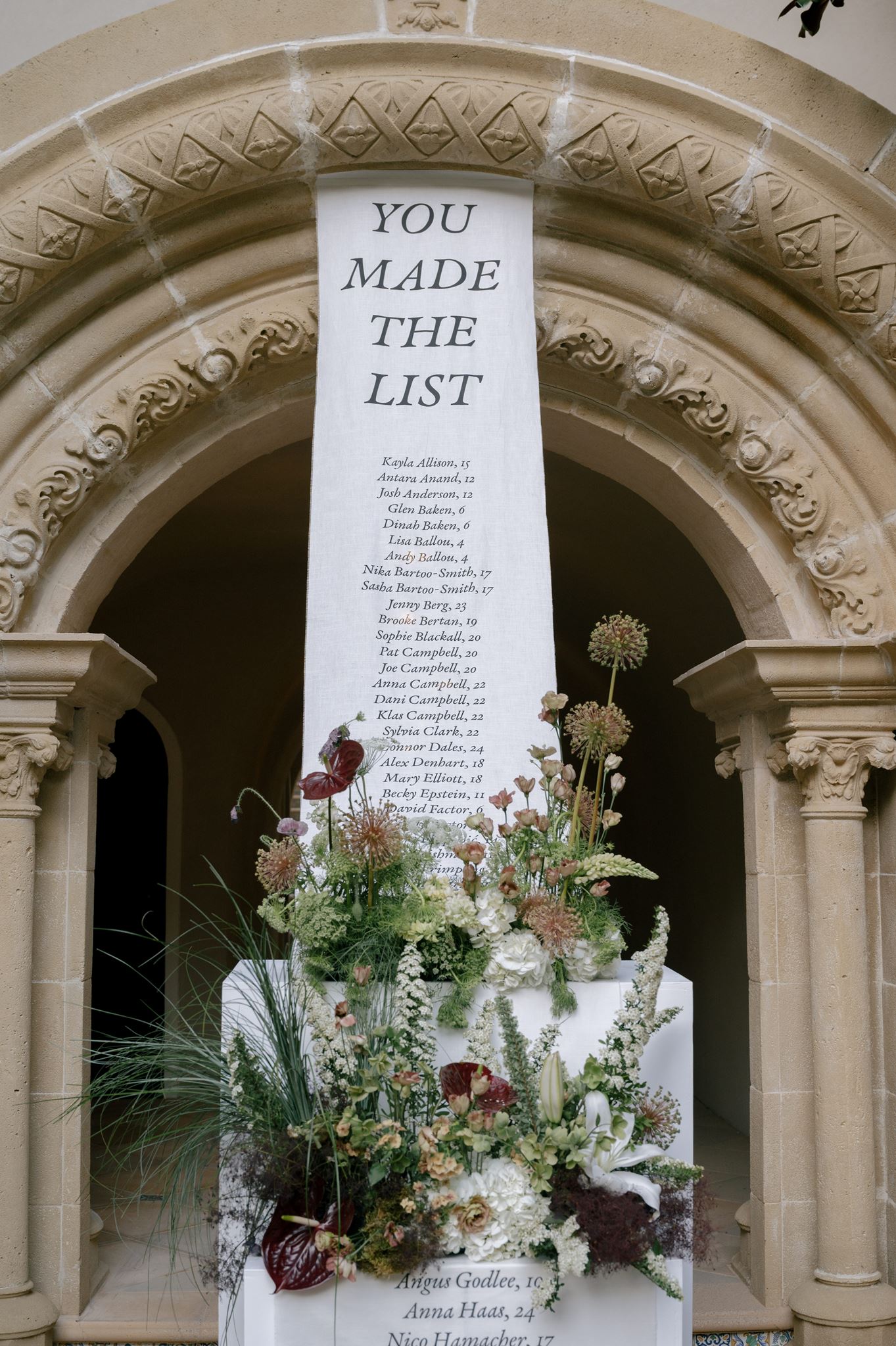 Grand linen seating chart and florals at a private estate wedding venue
